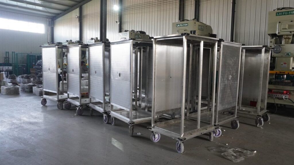 Stainless steel fabrication case: welded stainless trolleys with formed side panels, standing on their castors